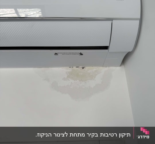 מזגן על קיר עם סימני רטיבות מתחתיו